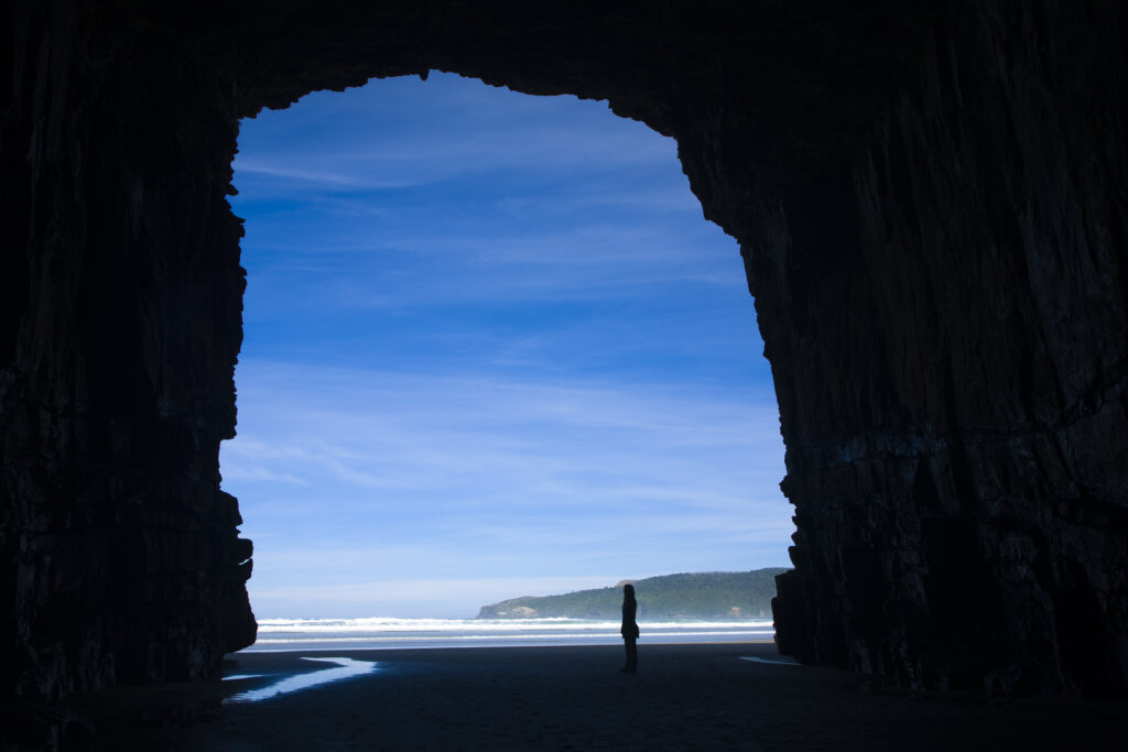 New Zealand, Southland, The Catlins. Tourist admiring the Cathedral caves.