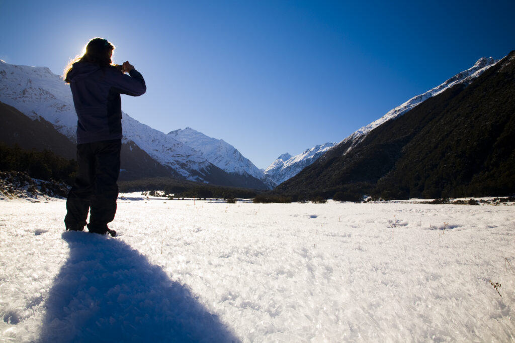 New Zealand, Otago, Mt Aspiring National Park. Tourist in the West Matukituki Valley taking a photograph of Mt Aspiring.