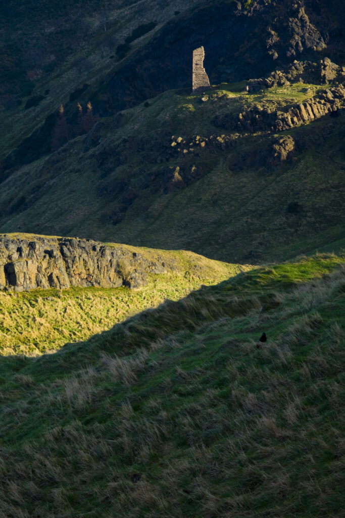 Scotland, Edinburgh, Holyrood Park. St Anthony's Chapel high above St Margaret's Loch, viewed from the Salisbury Crags.