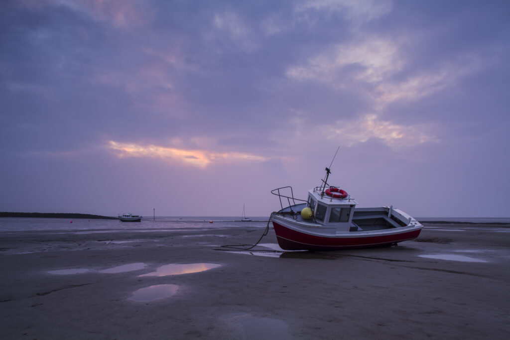 England, Lancashire, Morecambe. Fishing boat at low tide moored at Morecambe / Morecambe Bay.