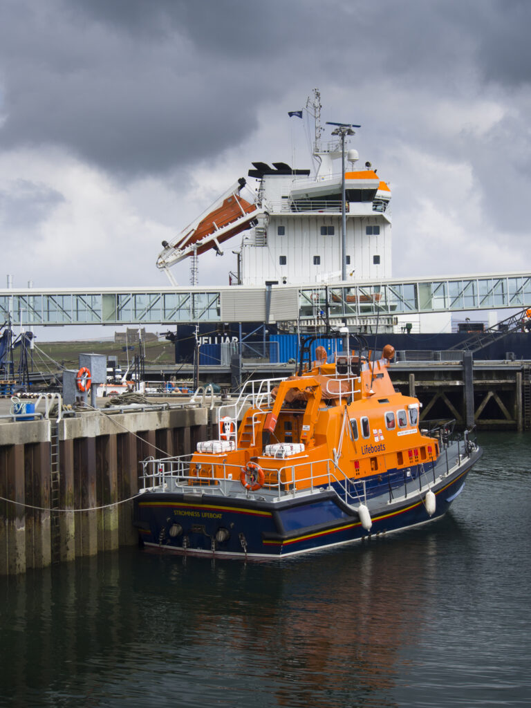 Scotland, Orkney Islands, Mainland Orkney. Lifeboat and other sea boats moored in Stromness Harbour on mainland Orkney.