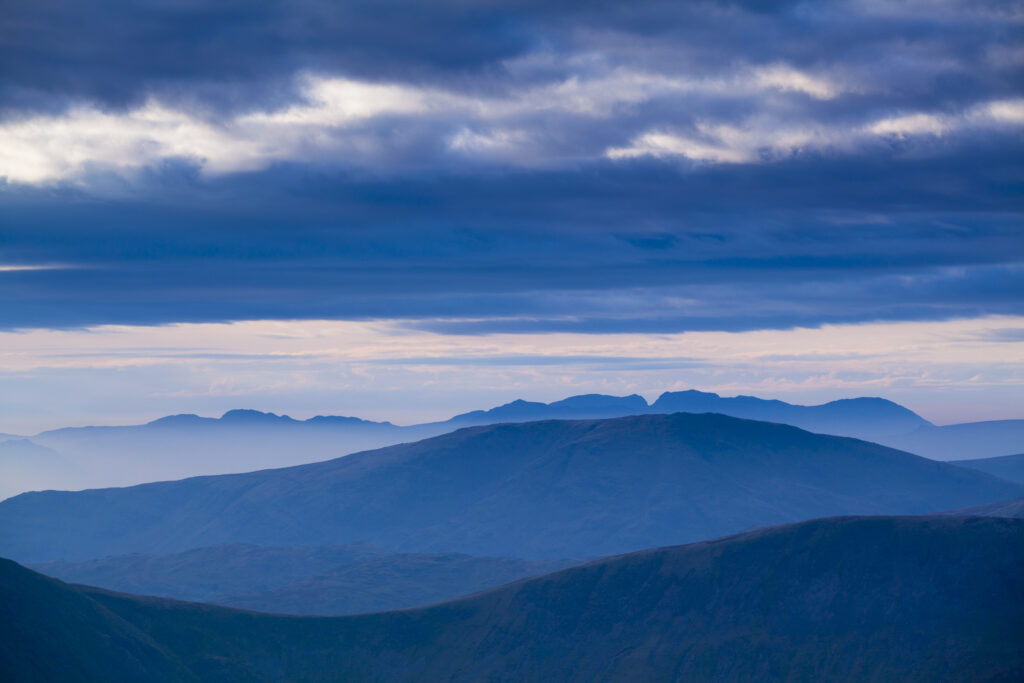 England, Cumbria, Lake District National Park. Mountain fog in the valleys of the western Lake District overlooked by the highest peak, Scafell Pike.