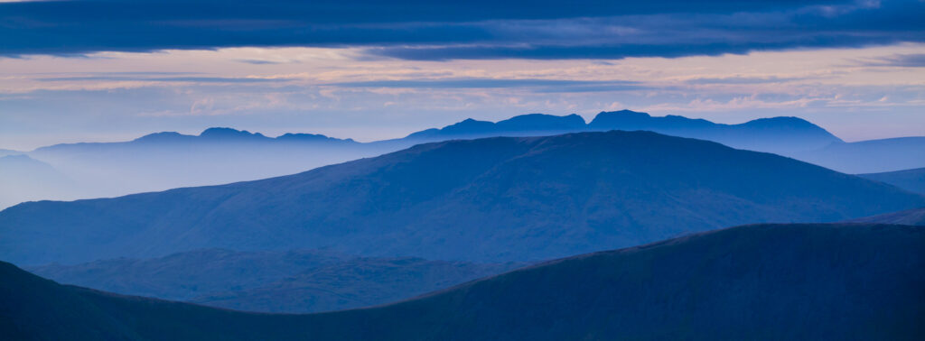 England, Cumbria, Lake District National Park. Mountain fog in the valleys of the western Lake District overlooked by the highest peak, Scafell Pike.