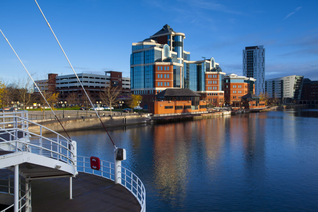 England, Greater Manchester, Salford Quays. Victoria Harbour building viewed from Detroit footbridge on the Manchester Ship Canal located in Salford.