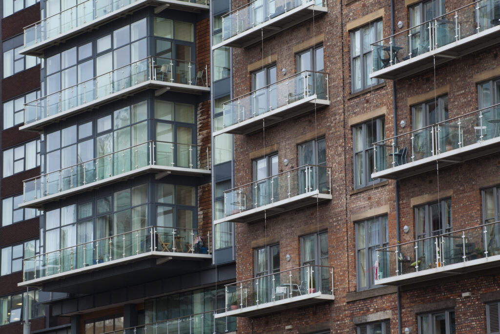 England, Greater Manchester, Manchester. Detail shot of modern apartments formed by redevolping Victorian warehouses located on the banks of the River Irwell near the Trinity Bridge.