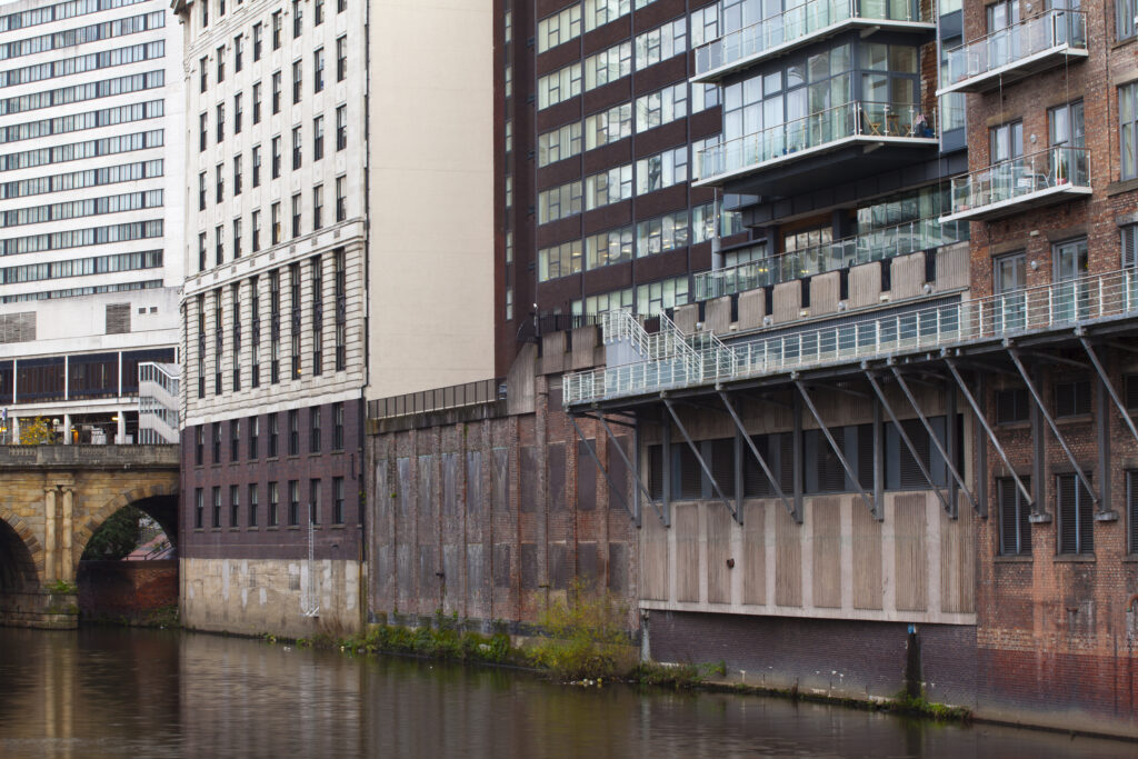 England, Greater Manchester, Manchester. Detail shot of modern apartments formed by redevolping Victorian warehouses located on the banks of the River Irwell near the Trinity Bridge.