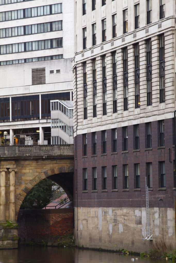 England, Greater Manchester, Manchester. Detail shot of modern apartments formed by redevolping Victorian warehouses located on the banks of the River Irwell near the Trinity Bridge.
