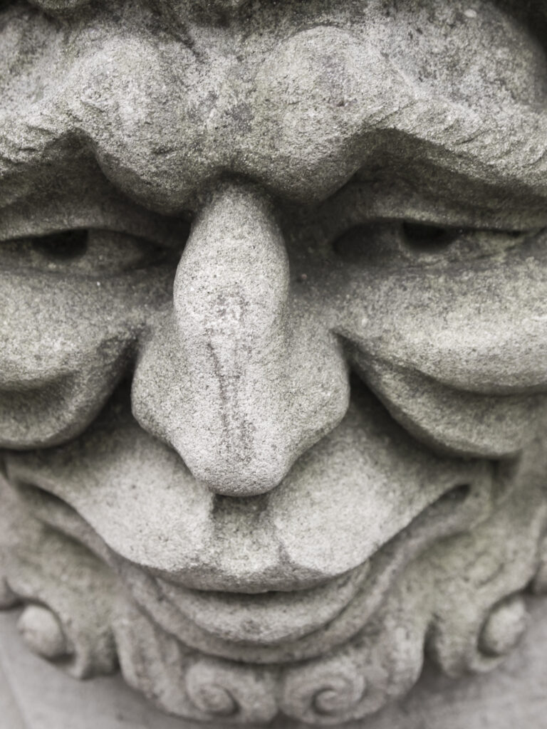 England, North Yorkshire, York City. Gargoyle on bench in Dean's Park in the grounds of York Minster cathedral.