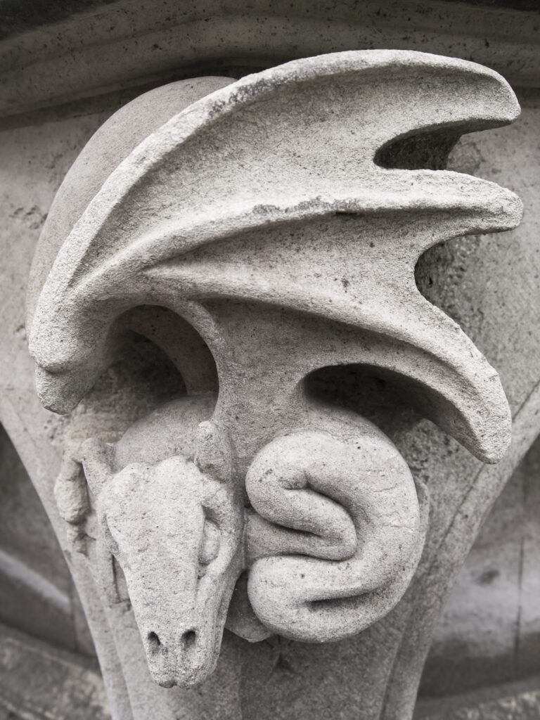 England, North Yorkshire, York City. Gargoyle on bench in Dean's Park in the grounds of York Minster cathedral.