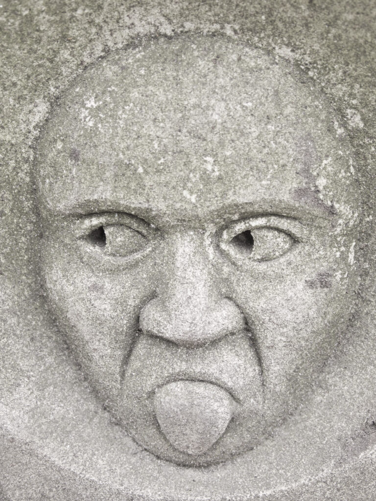 England, North Yorkshire, York City. Gargoyle on bench in Dean's Park in the grounds of York Minster cathedral.
