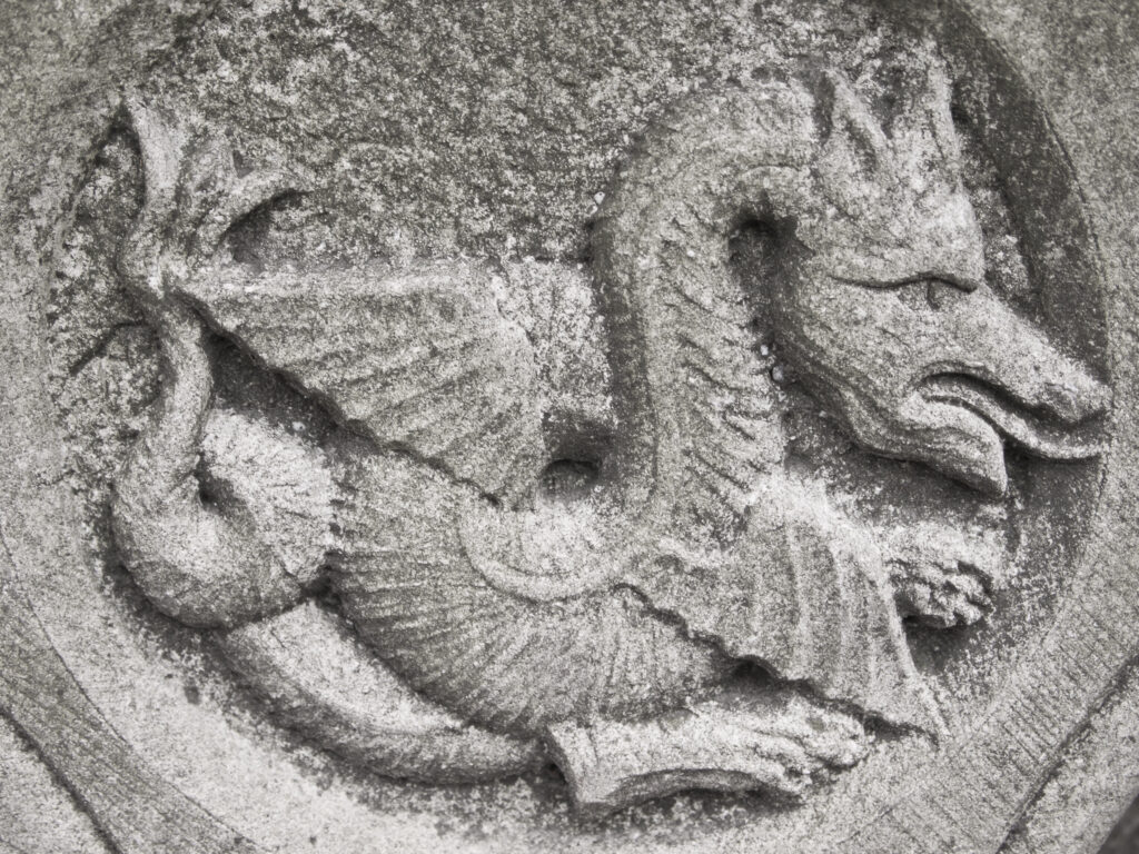 England, North Yorkshire, York City. Gargoyle on bench in Dean's Park in the grounds of York Minster cathedral.