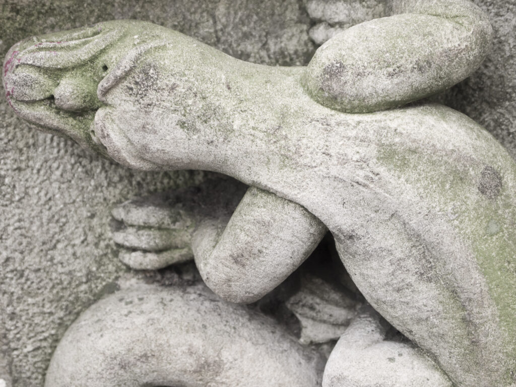 England, North Yorkshire, York City. Gargoyle on bench in Dean's Park in the grounds of York Minster cathedral.