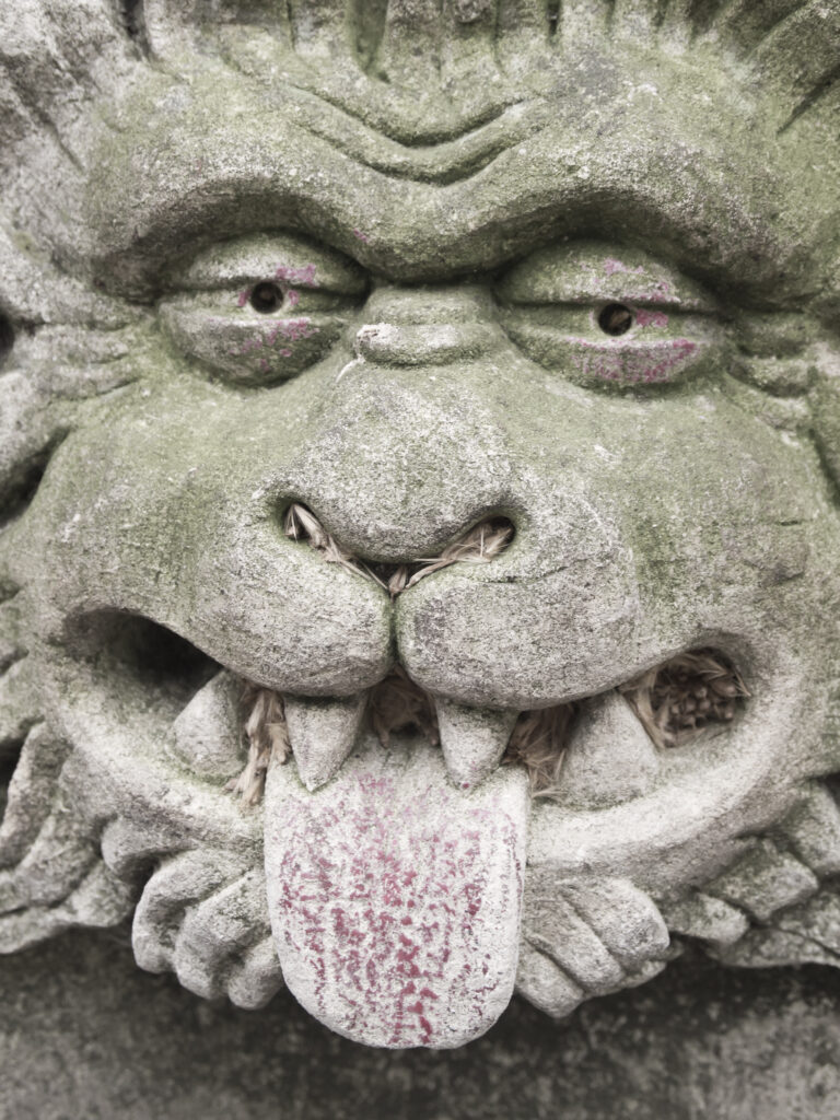 England, North Yorkshire, York City. Gargoyle on bench in Dean's Park in the grounds of York Minster cathedral.