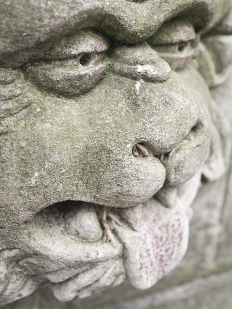 England, North Yorkshire, York City. Gargoyle on bench in Dean's Park in the grounds of York Minster cathedral.