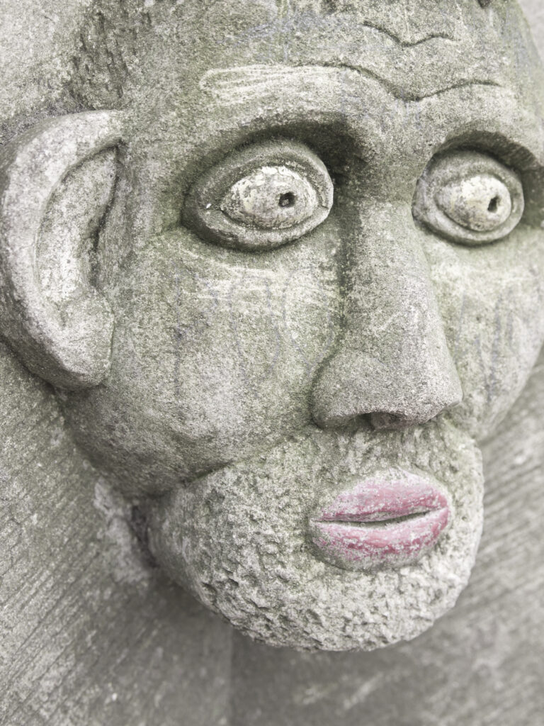 England, North Yorkshire, York City. Gargoyle on bench in Dean's Park in the grounds of York Minster cathedral.