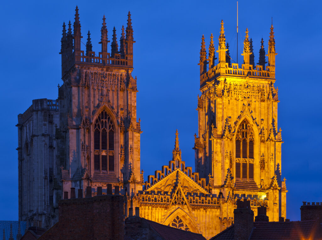 England, North Yorkshire, York City. The West Front of York Minster, above the nearby roof tops.