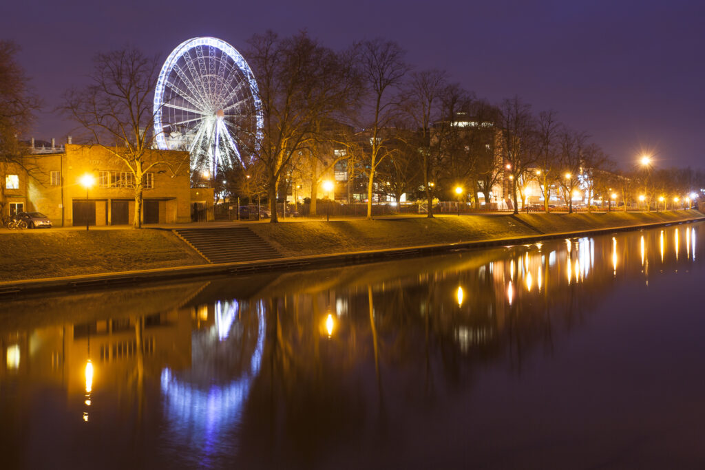 England, North Yorkshire, York City. York Eye Ferris wheel reflected at dusk in the still waters of the River Ouse.