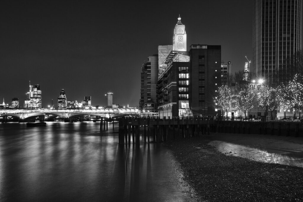 England, London, OXO Tower. The OXO Tower viewed from upstream of the River Thames, with Sea Containers House and the City Of London and Gherkin building beyond.