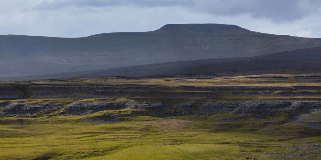 England, North Yorkshire, Yorkshire Dales National Park. Looking towards the peak of Ingleborough and the Moughton Scars, a natural karst landform (limestone pavement) which is common in the Yorkshire Dales.