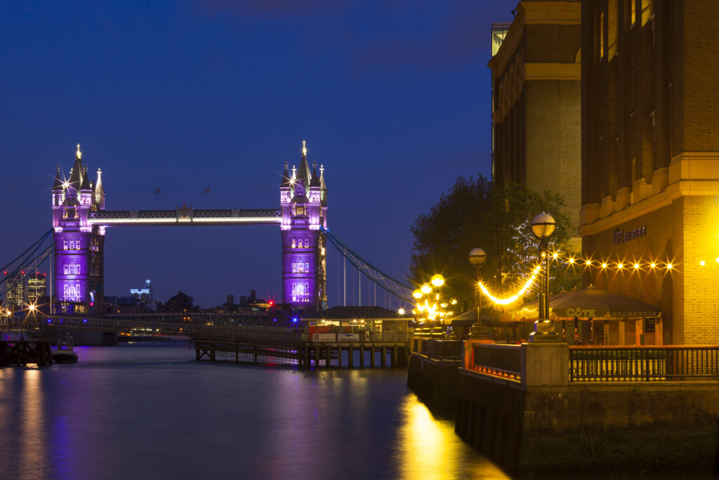 England, London, Southwark. HMS Belfast, originally a Royal Navy light cruiser, permanently moored in London on the River Thames with Tower Bidge in the distance.