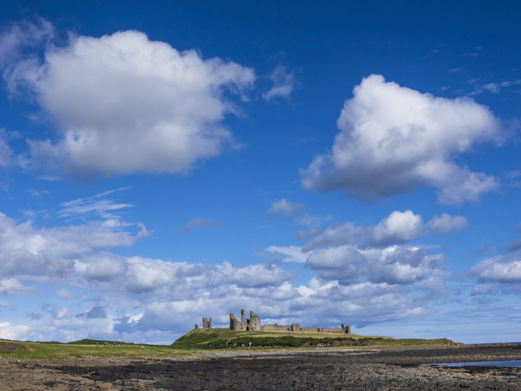 England, Northumberland, Dunstanburgh Castle. Dunstanburgh Castle and surrounding coastline at low tide.