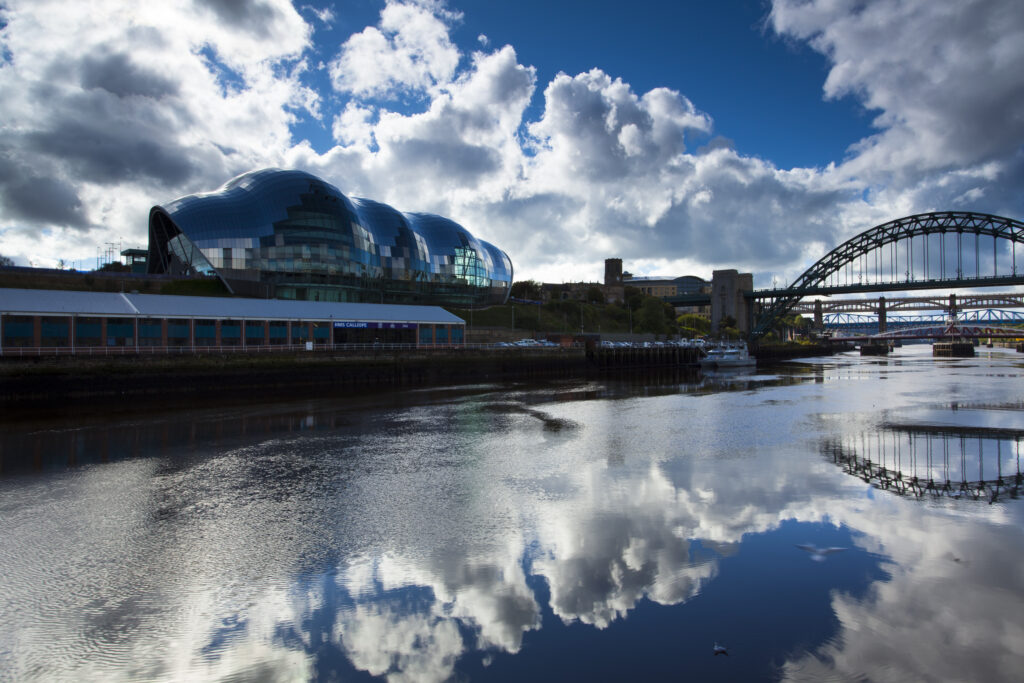 England, Tyne and Wear, Newcastle Upon Tyne. The Sage Building and world-famous Tyne Bridge, crossing the Newcastle Upon Tyne and Gateshead Quayside.
