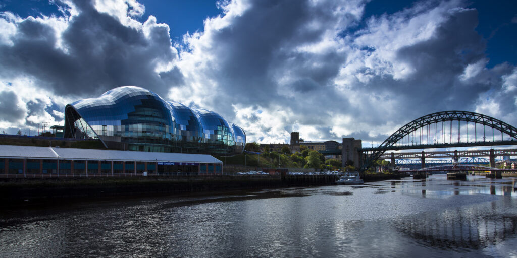 England, Tyne and Wear, Newcastle Upon Tyne. The Sage Building and world-famous Tyne Bridge, crossing the Newcastle Upon Tyne and Gateshead Quayside.