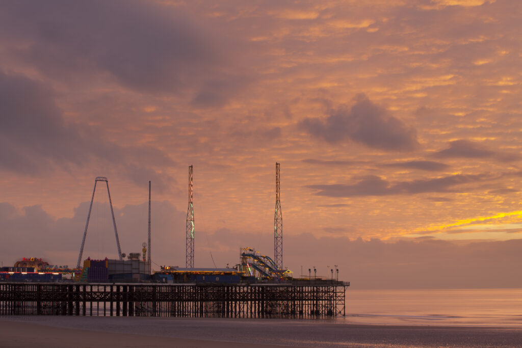 England, Lancashire, Blackpool. Blackpool South Pier at sunset.