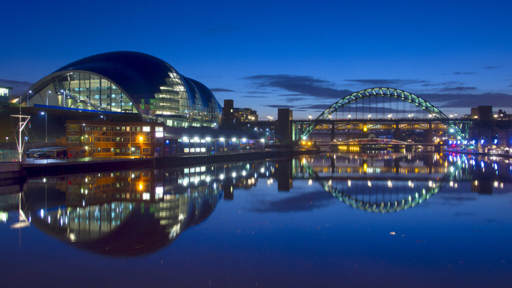 England, Tyne and Wear, Newcastle Upon Tyne. The Sage Building and the Tyne Bridge crossing the River Tyne and joining the Newcastle / Gatehead Quayside.