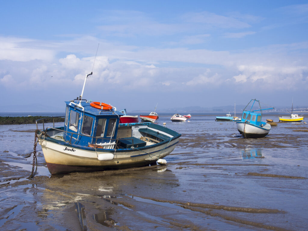 England, Lancashire, Morecambe. Fishing boats at low tide moored at Morecambe / Morecambe Bay.