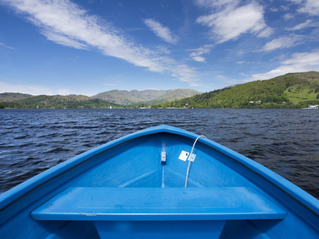 England, Cumbria, Lake District National Park. Lakeland mountains viewed from rowing boat on Lake Windermere.