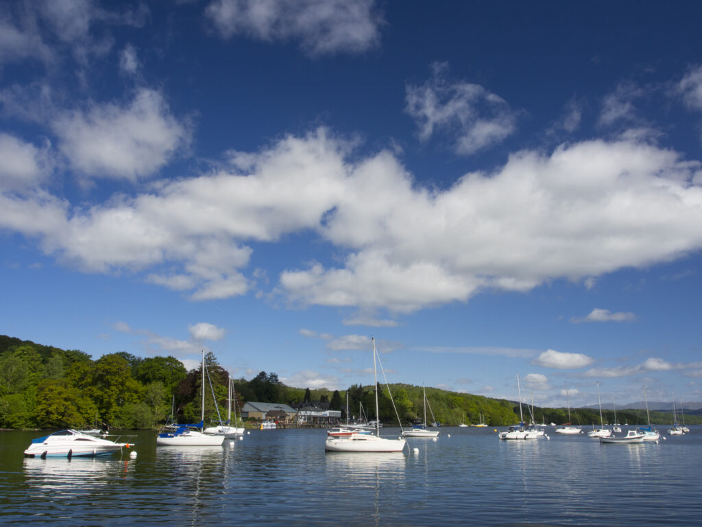 England, Cumbria, Lake District National Park. Sailing boats on the southern tip of Lake Windermere near Fell Foot Park. Lakeside can be viewed in the distance.