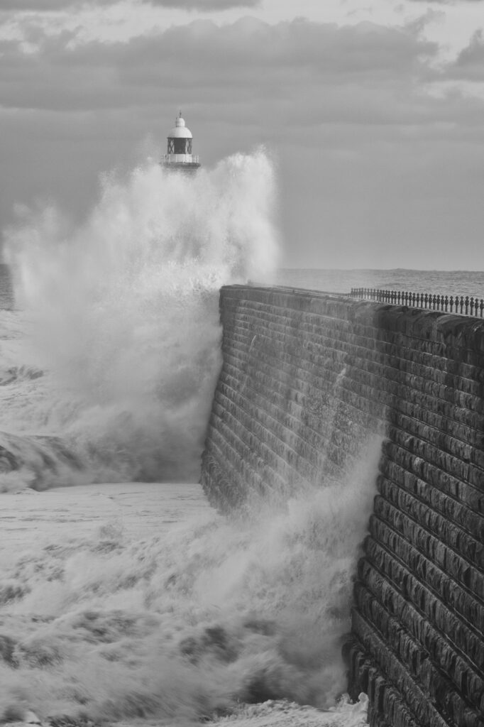England, Tyne and Wear, Tynemouth. Waves crash at the mouth of the River Tyne, during a winter storm.