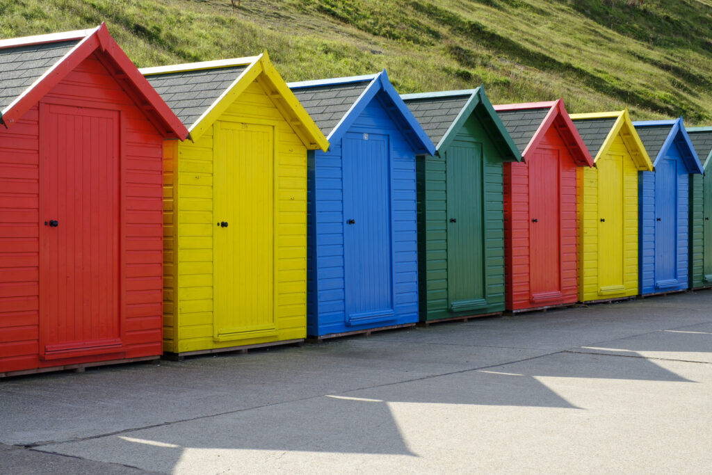 England, North Yorkshire, Whitby. Colourful seaside beach huts at Whitby in North Yorkshire.