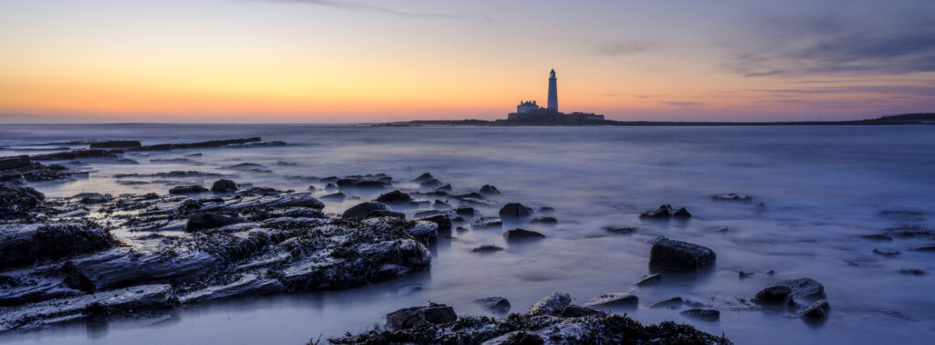 England, Northumberland, Old Hartley. Old Hartley Bay at dawn, looking towards St Mary's Lighthouse.