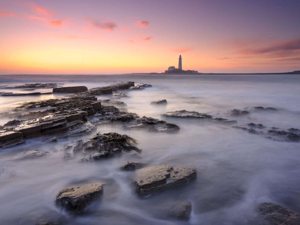 England, Northumberland, Old Hartley. Old Hartley Bay at dawn, looking towards St Mary's Lighthouse.