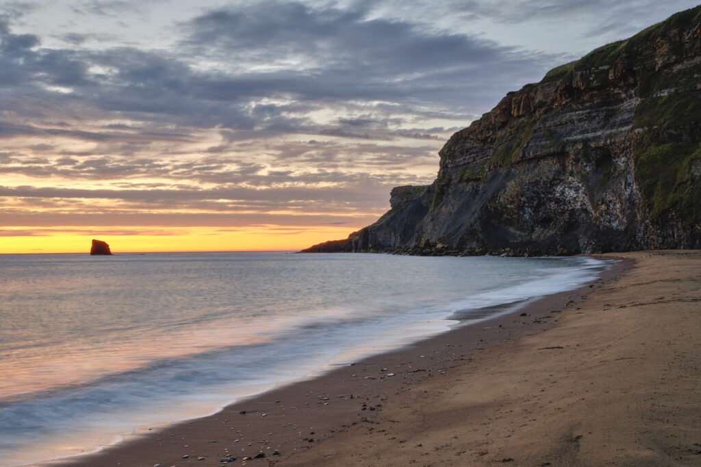 England, North Yorkshire, North York Moors National Park. Early morning light at Saltwick Bay and Nab near Whitby.