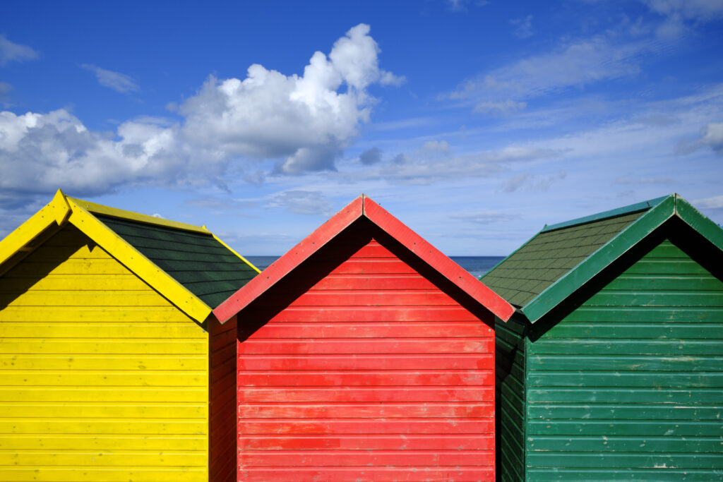England, North Yorkshire, Whitby. Colourful seaside beach huts at Whitby in North Yorkshire.