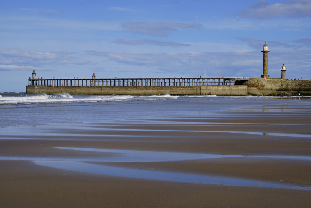 England, North Yorkshire, Whitby. Whitby beach and pier.