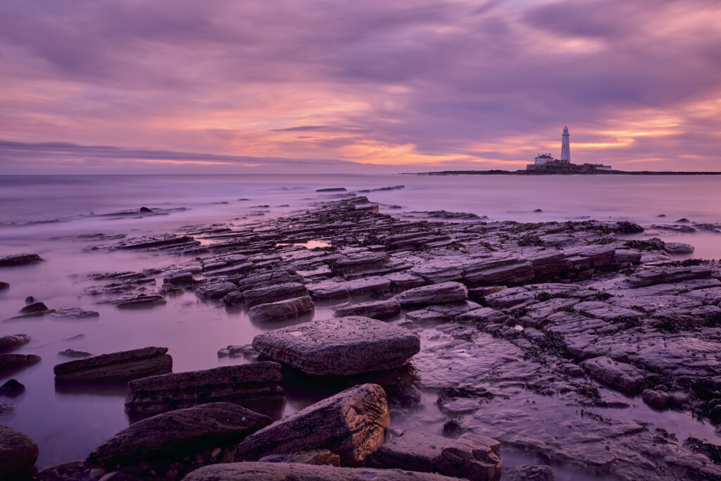 England, Northumberland, Old Hartley. Old Hartley Bay at dawn, looking towards St Mary's Lighthouse.
