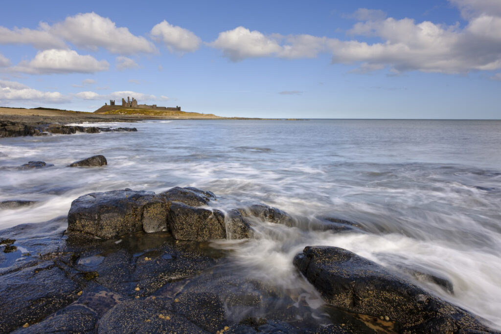 England, Northumberland, Dunstanburgh Castle. Dunstanburgh Castle viewed from near the village of Craster.