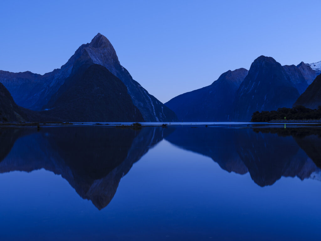 New Zealand, South Island, Fiordland National Park. The blue tones of pre-dawn at the Milford Sound.