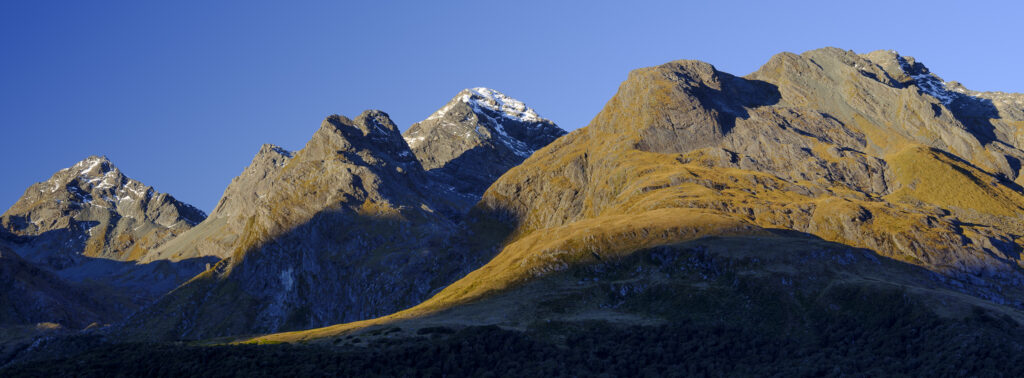 New Zealand, South Island, Fiordland National Park. Late afternoon light on the mountain peaks of the Fiordland National Park viewed from the Key Summit track.