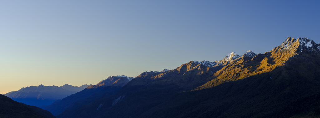 New Zealand, South Island, Fiordland National Park. Late afternoon light on the mountain peaks of the Fiordland National Park viewed from the Key Summit track.