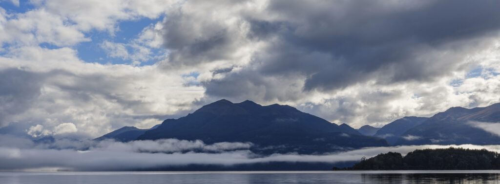 New Zealand, South Island, Fiordland National Park. Morning mist at Fiordland National Park, viewed from the shores of Lake Te Anau.