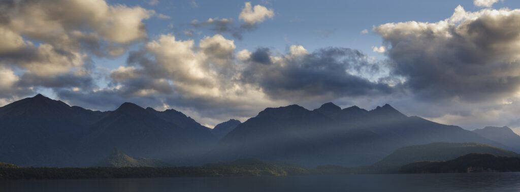 New Zealand, Southland, Lake Manapouri. Storm clouds over the mountain peaks of Fiordland National Park viewed from Fraser Beach at Manapouri.