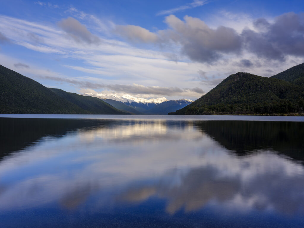 New Zealand, South Island, Nelson Lakes National Park. Reflections on the still waters of Lake Rotoroa at sunset.
