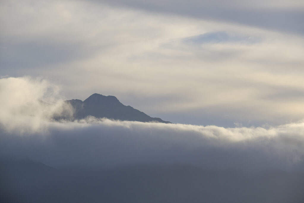 New Zealand, South Island, Fiordland National Park. Cloud surrounds one of the mountain peaks of the Fiordland National Park, viewed from the shores of Lake Te Anau.