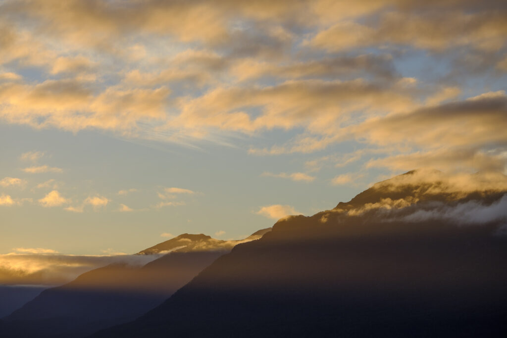New Zealand, South Island, Fiordland National Park. Last light on the mountain peaks of the Fiordland National Park, viewed from the shores of Lake Te Anau.