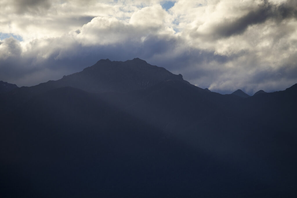 New Zealand, Southland, Lake Manapouri. Storm clouds over the mountain peaks of Fiordland National Park viewed from Fraser Beach at Manapouri.